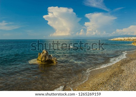 tropic sea sand and rocky beach scenic nature landscape view with vivid blue water color surface in clear summer season weather time
