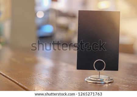 Black label in cafe. display stand for acrylic tent card in coffee shop. mockup menu frame on table in bar restaurant. space for text
