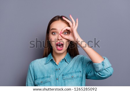 Close up portrait of fooling crazy gesturing attractive girl woman showing ok glasses symbol opened mouth in denim clothes outfit isolated on grey background