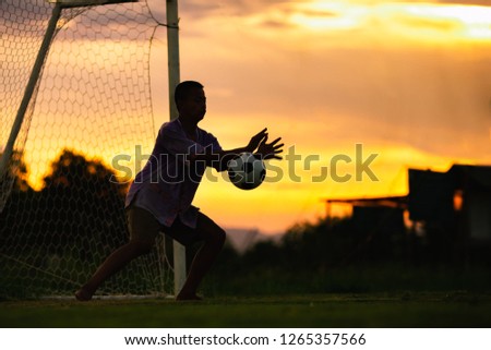 Action picture with copy space of young boy playing soccer football as a goal keeper which is good exercise activity to learn the rules and team work for kids.