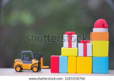 Forklift truck with christmas gift box. Delivering presents concept