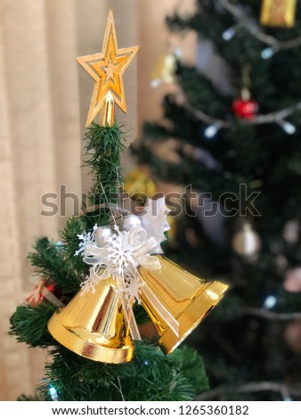the star and bells hanging decorated on Christmas tree for celebration Jesus birthday festival season