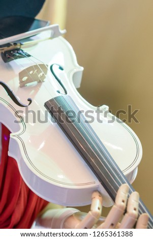 White violin in the hands of a robot. The robot playing the violin. vertical photo