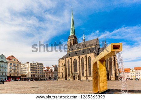St. Bartholomew's Cathedral in the main square of Plzen with a fountain on the foreground against blue sky and clouds sunny day. Czech Republic, Pilsen. Famous landmark in Czech Republic, Bohemia. Royalty-Free Stock Photo #1265365399