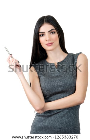 Young business woman holding a pen and looking at the camera.
