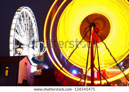 long exposure pictures of amusement park rides and wheels at night