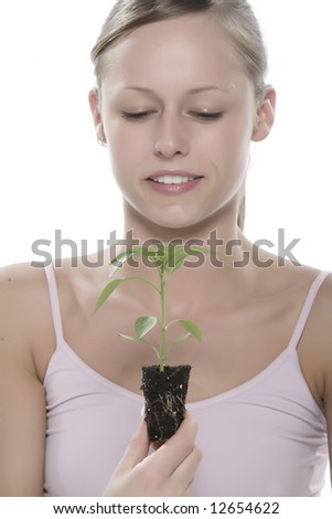 Beautiful blond girl holding young plant