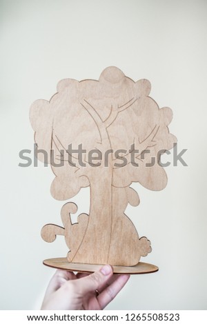 Wooden figure of a tree with traced branches. Easter or geneological. Plain beige background