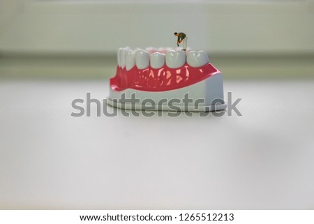 Small assistants in the dental clinic. Men treat teeth, brush teeth, repair different equipment. Bright screen saver for a dental clinic. Little man toy seals big teeth.