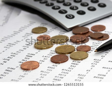 Financial accounting, Image a plurality of numbers on paper and calculator, Numbers on paper, a pen and a calculator, coins.