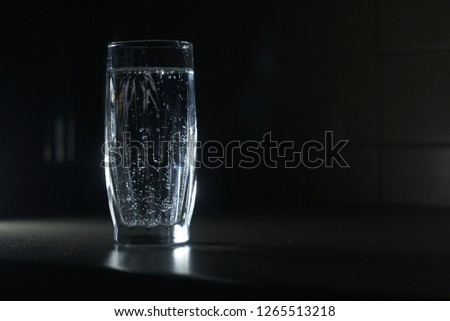  a glass of soda water on a dark background                              