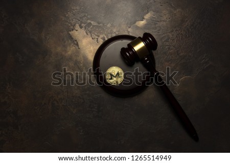  golden monero lie with judge gavel on aged background