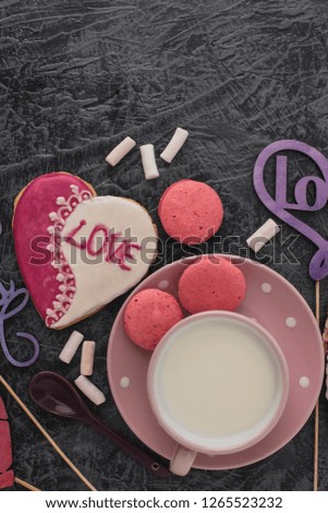 Romantic Valentine's Day breakfast. Heart-shaped cookies and a cup of milk on a gray table. Top view