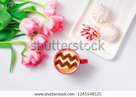 a cup of cappuccino coffee with a pattern of the aquarius zodiac sign on milk foam