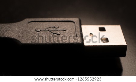 Black USB 2.0 cable with type B connector on a dark background. Macro Image