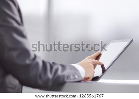 businessman uses a digital tablet sitting at a table in a cafe