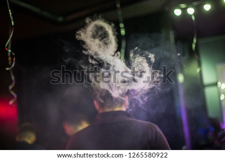 Circle of smoke from electronic cigarettes. Couples from vape. Smoke from the mouth of smoking man. Men vaping and lets out circles of smoke.