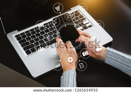 Woman hand using smart phone, mobile payments online shopping, omni channel, digital tablet docking computer in office virtual interface icons screen. top view 
