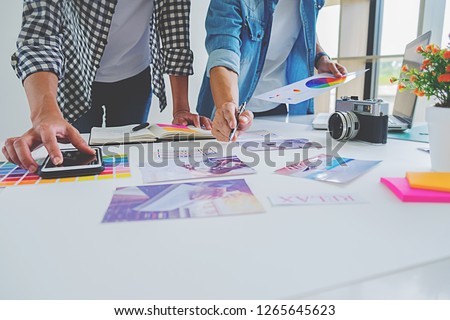 Asian advertising designer creative start-up team discussing ideas in office. Royalty-Free Stock Photo #1265645623