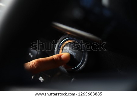 A finger touching car engine start button. Royalty-Free Stock Photo #1265683885