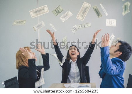 Happy businessman and woman enjoying the rain of money with smiling for success work. Rich money concept.