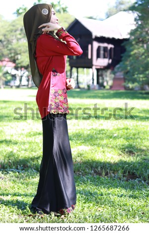 Beautiful young Asian lady wearing hijab. Cute girl in modest fashion. Malay traditional attire "kurung". Malay traditional concept photo. Royalty-Free Stock Photo #1265687266