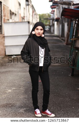 Full body portrait shot of girl posing for street style fashion. Girl wearing hijab. Black fashion style inspiration. 