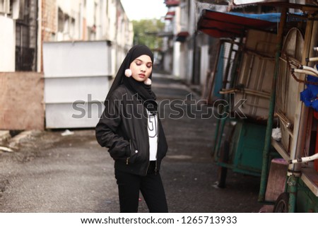 Full body portrait shot of girl posing for street style fashion. Girl wearing hijab. Black fashion style inspiration. 