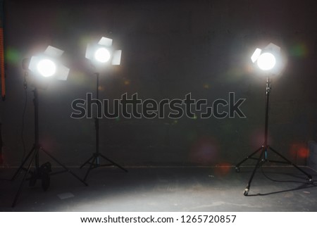 Several reflectors on the black background in photo studio. Preparing for professional photo shooting