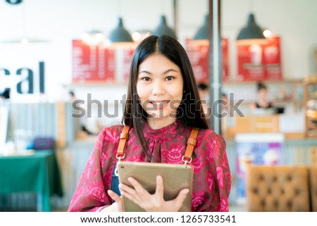 Smart business entrepreneur smiling women using tablet computer standing with coffee shop background owner cafe