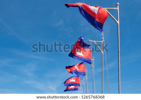 Flag of Cambodia waving in the wind against blue sky. The symbol emblem of Cambodia.