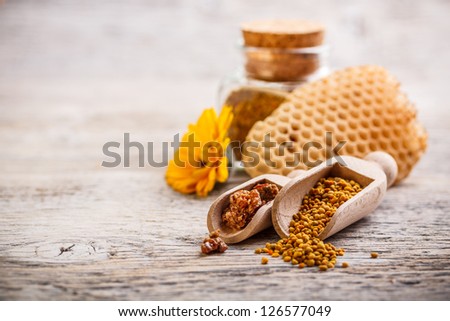 Bee pollen granules and propolis in wooden scoop Royalty-Free Stock Photo #126577049