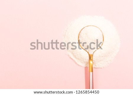 Collagen powder on pink background. Extra protein intake. Natural beauty and health supplement for skin, bones, joints and gut. Plant or fish based. Flatlay, top view. Copy space for your text. Royalty-Free Stock Photo #1265854450