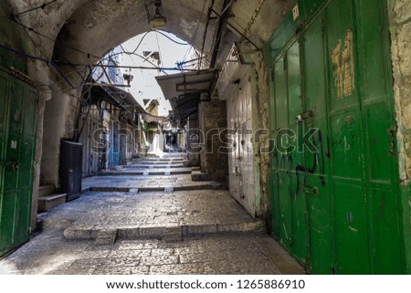 The empty street with closed shops in the Old City of Jerusalem in the early morning.