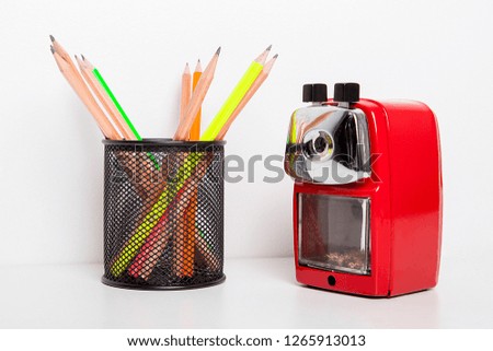 Heavy duty desk top pencil sharpener with pencils isolated on a white background.