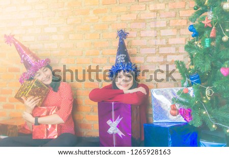 Happy family smiling and holding a lot of Christmas gifts in the room with Cristmas tree for celebration Christmas eve and Happy new year concept.