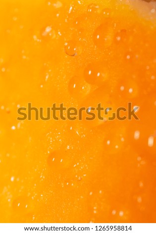 Drops of juice on pumpkin pulp as abstract background .