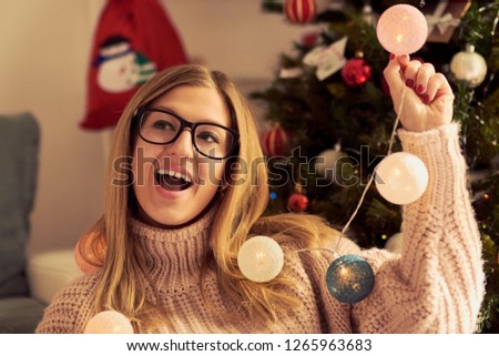 Portrait of beautiful woman enjoying near Christmas tree.