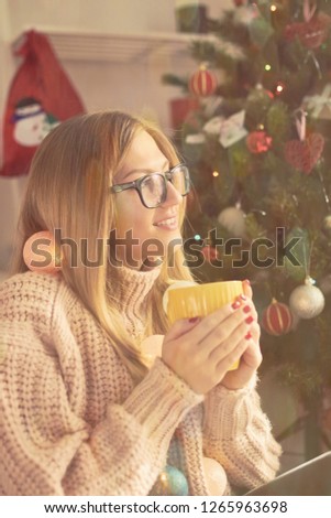 Portrait of beautiful woman drinking coffee and enjoying Christmas eve/New year's.