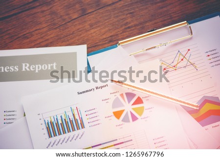 Business report chart preparing graphs concept / Summary report in Statistics circle Pie chart on paper business document financial chart and graph with  pen on the wooden table background 