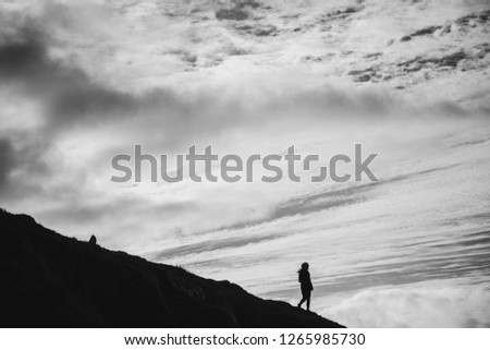 Silhouette of a woman with dark clouds in the background, black and white 