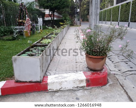Road footpath with traffic sign white and red color,sign of no parking. It is sidewalk pavement in front of the garden of one building.Walkway concept.