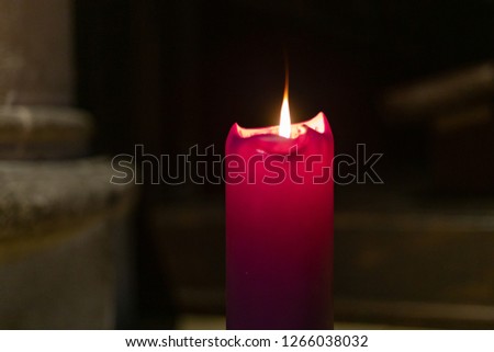 violet candle in church at advent christmas time in december month