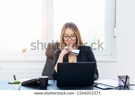 Young girl paying her online order with credit card at work.
