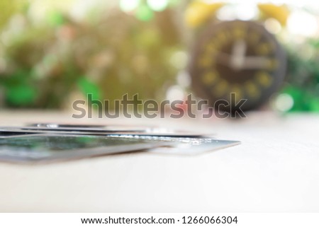 Credit card. Alarm clocks on wooden table colorful bokeh blurred  background. Payment with credit cash less society concept.