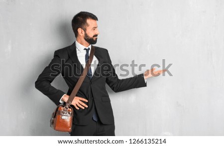 Businessman with beard pointing back and presenting a product