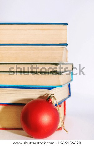 Stack of books with a red Christmas ball on a white background, New Year's design, Christmas concept