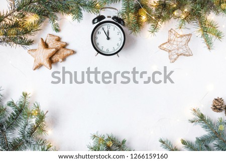 New Year and Christmas concept. Christmas tree, Christmas alarm clock 23:55 , cookies, festoon on a light background