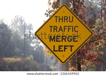 Thru traffic merge left street sign