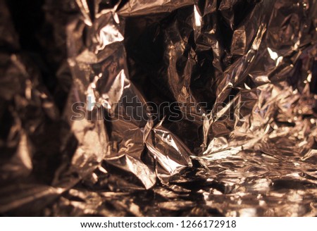 A surface with many faces. Silver metallic luster. Crumpled foil. Abstract background photography